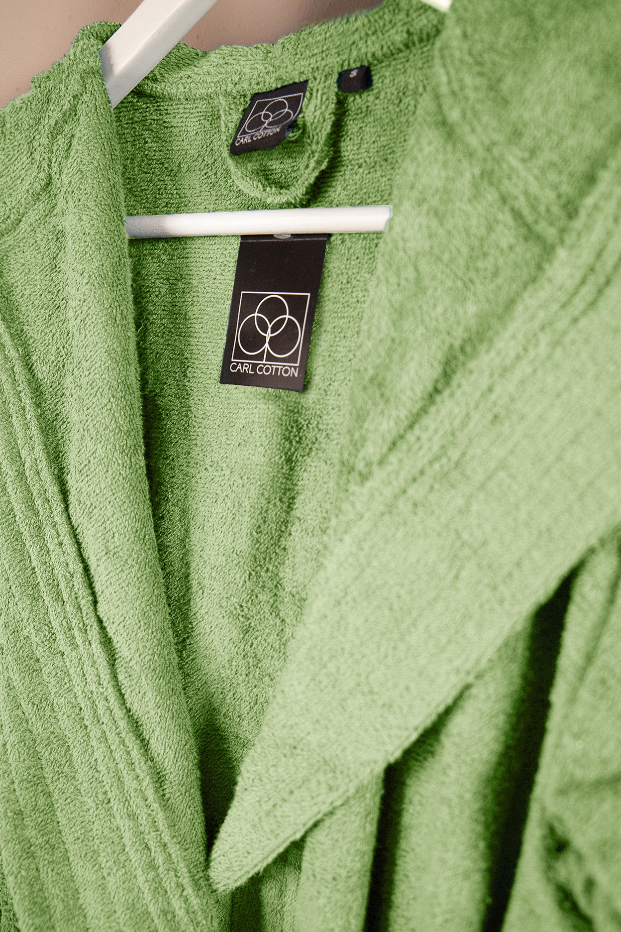 Eine Detailaufnahme des Stoffes vom CARL COTTON Bademantel in der Farbe Gruen. Die Struktur wird hervorgehoben. Modell Avocado.