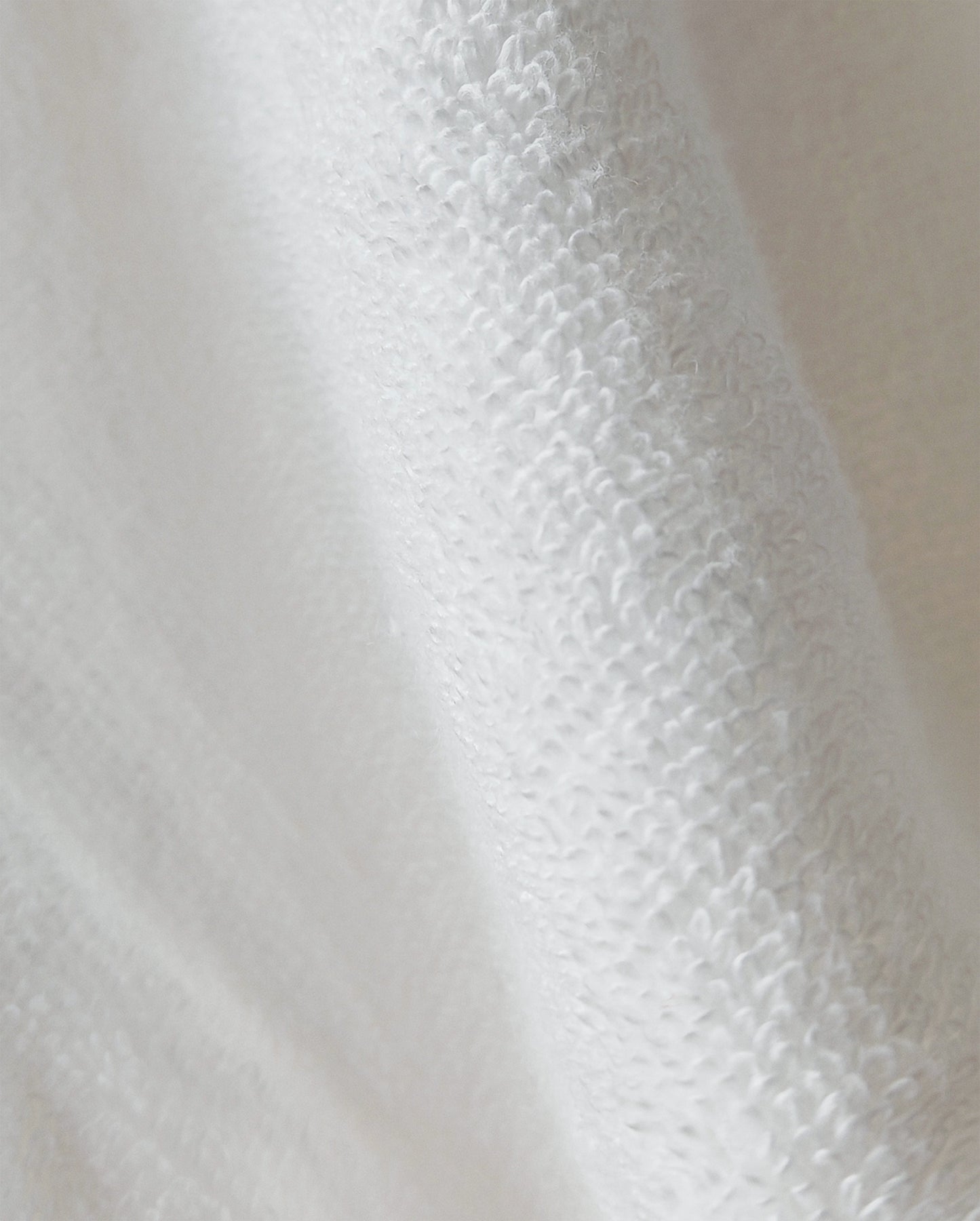 Eine Detailaufnahme des Stoffes vom EN VOGUE Bademantel in der Farbe Weiss. Die Struktur wird hervorgehoben. Modell Air Cotton Weiss.