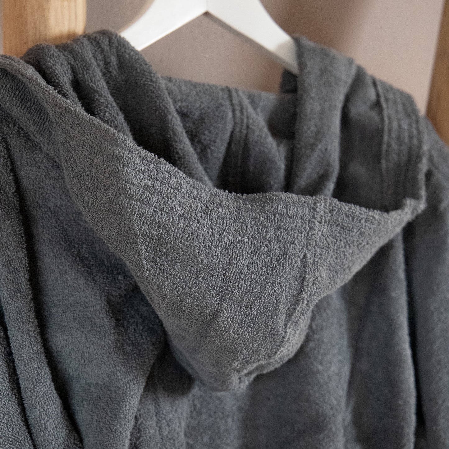 Eine Detailaufnahme der Kapuze vom NATURAWALK Bademantel in der Farbe Anthrazit. Die Struktur wird hervorgehoben. Modell Anthrazit.