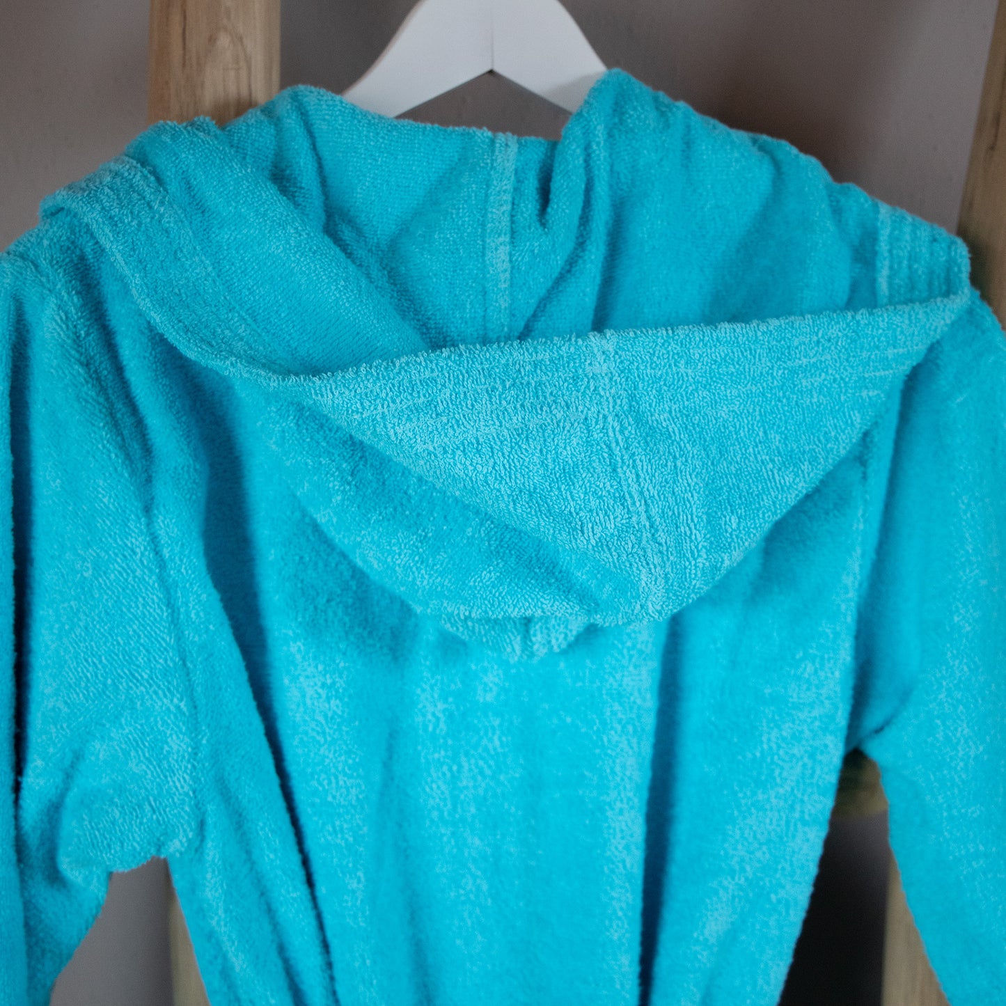 Eine Detailaufnahme der Kapuze vom NATURAWALK Bademantel in der Farbe Tuerkis. Die Struktur wird hervorgehoben. Modell Tuerkis.
