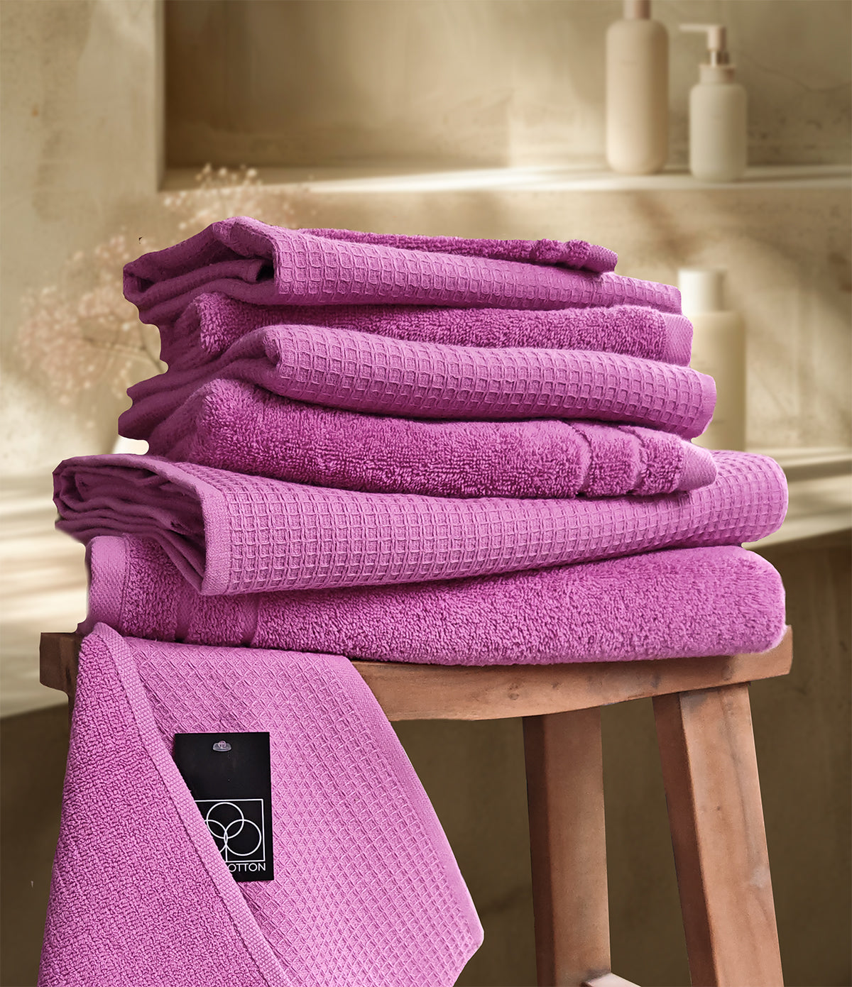 Ein Stapel aus mehreren Handtuechern die aufeinander liegen in der Farbe Pink. Modell Waffelpique Crocus.