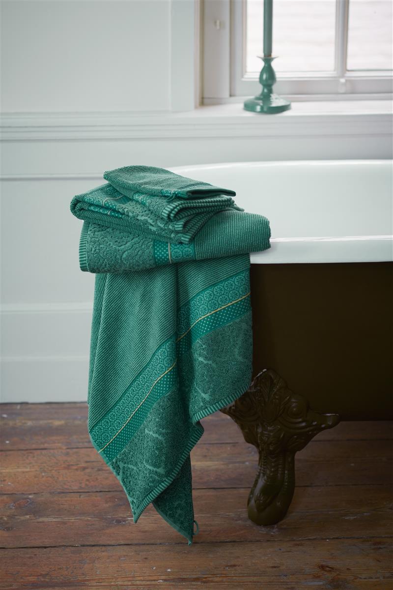 Ein Stapel aus mehreren Handtuechern von PIP STUDIO die aufeinander liegen mit Muster aus grafischen Formen in der Farbe Gruen. Modell Soft Zellige Green.