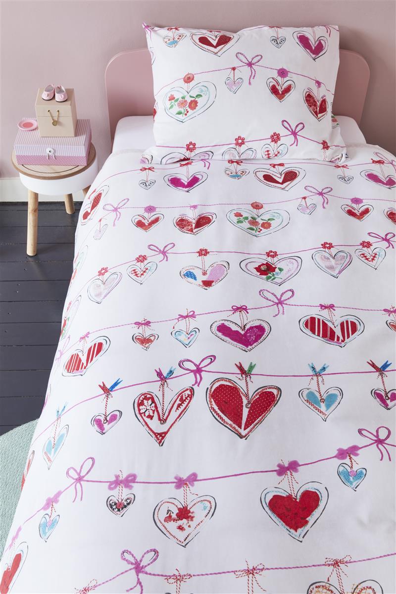 In einem Kinderschlafzimmer steht ein Bett mit einem Kopfkissen und einer Bettdecke bezogen mit kuscheliger beddinghouse Bettwaesche aus 100 Prozent Baumwolle mit Illustrationen von Herzen der Farbe Weiss. Modell Hearts.