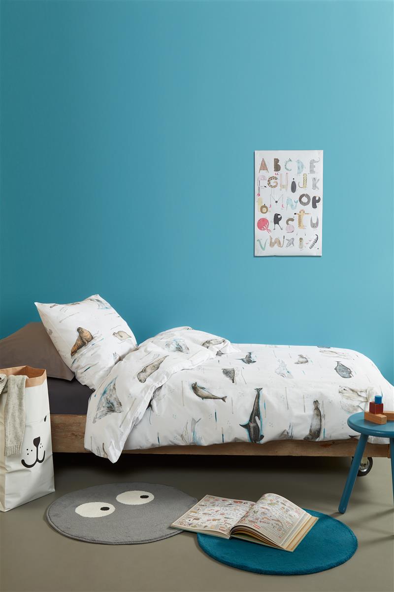 In einem Kinderzimmer steht ein Kinderbett mit einem Kopfkissen und einer Bettdecke bezogen mit kuscheliger beddinghouse Bettwaesche aus 100 Prozent Baumwolle mit Illustrationen von Polartieren in der Farbe Weiss. Modell Polar Adventure.