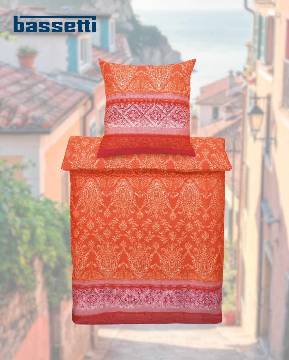 Ein Kopfkissen und eine Bettdecke bezogen mit eleganter Mako-Satin Bettwaesche von bassetti mit einem Paisleymuster in der Farbe Orange. Modell Faraglioni 01.