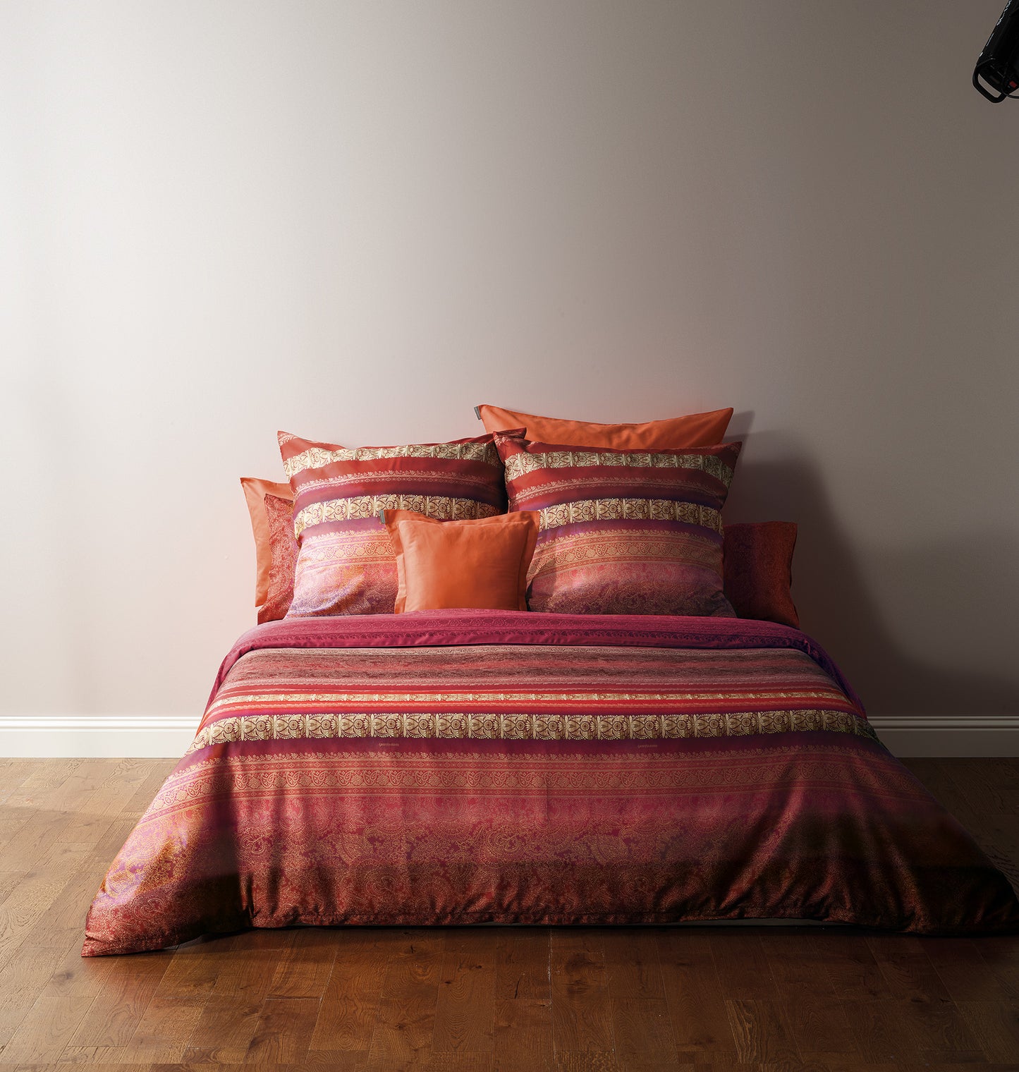 Mehrere Kopfkissen und eine Bettdecke bezogen mit eleganter Mako-Satin Bettwaesche von bassetti mit einem gestreiftem Paisleymuster in der Farbe Rot. Modell Ispica R2