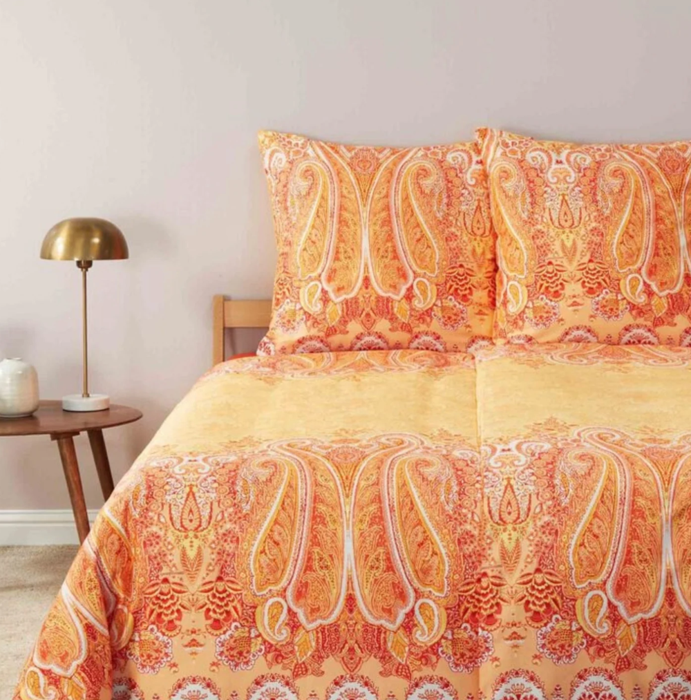 Zwei Kopfkissen und eine Bettdecke bezogen mit eleganter Mako-Satin Bettwaesche von bassetti mit einem Paisleymuster in der Farbe Orange. Modell Mergellina O1.
