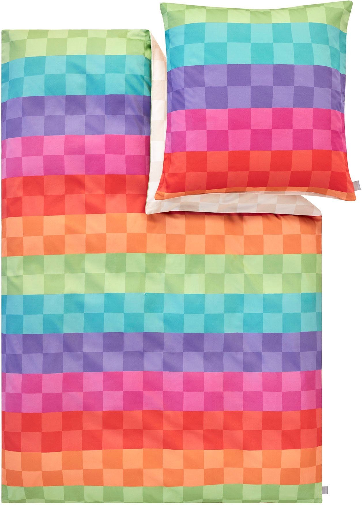 Ein Kopfkissen und eine Bettdecke bezogen mit Mako-Satin Bettwaesche mit einem Muster aus Quadraten in der Farbe Mehrfarbig. Modell Puwei.