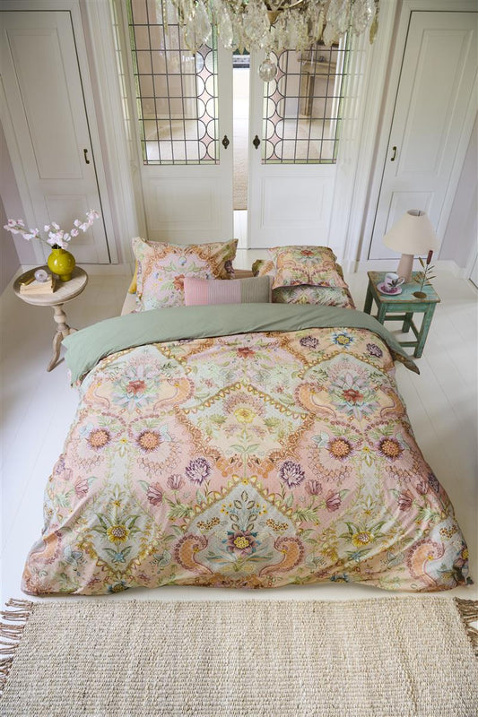 Auf einem Bett liegen mehrere Kopfkissen und eine Bettdecke bezogen mit Perkal-Baumwoll Bettwaesche aus 100 Prozent Baumwolle mit Muster aus Blumen in der Farbe Rosa. Modell Saluti Grandi Pastell.