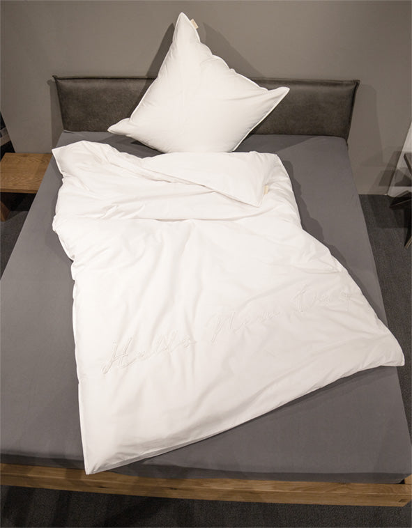 Ein Bettbezug-Set aus einem Kopfkissen und einer Bettdecke bezogen mit Perkal-Baumwoll Bettwaesche aus 100 Prozent Baumwolle in der Farbe Weiss. Modell Hello New Day Weiß.