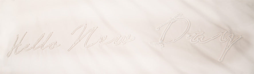 Detaildarstellung des Schriftzuges der Perkal-Baumwoll Bettwaesche Modell Hello New Day Weiß.