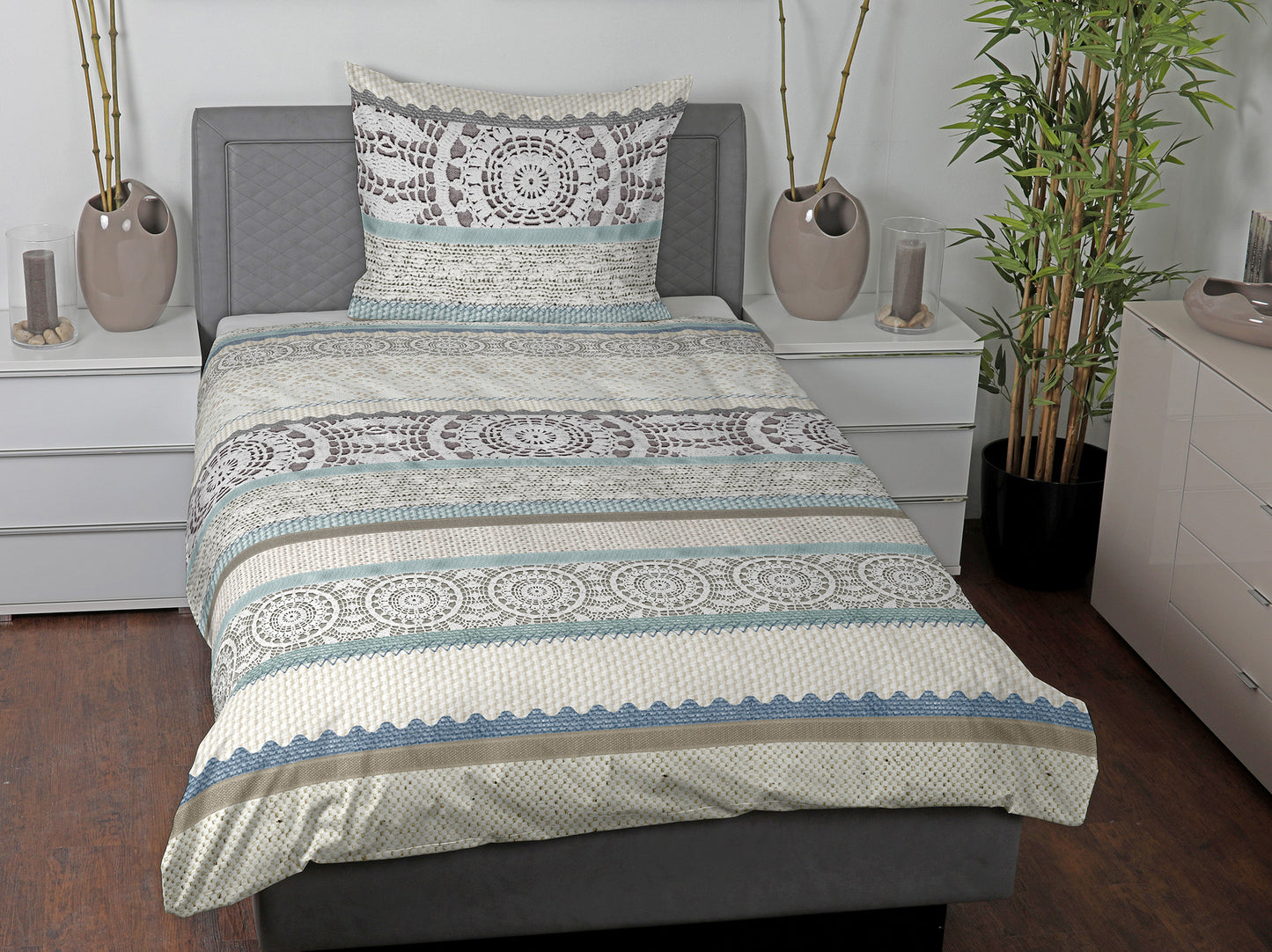 Im Schlafzimmer: Ein Kopfkissen und eine Bettdecke bezogen mit seidig-weicher Satin Bettwaesche von Casatex mit einem Muster in der Farbe Mint. Modell Summerlive.