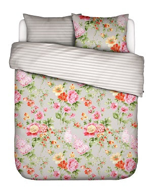 Ein Kopfkissen und eine Bettdecke bezogen mit Satin Bettwaesche von Essenza mit einem Muster aus Blumen in der Farbe Beige. Modell Claudia Stone.