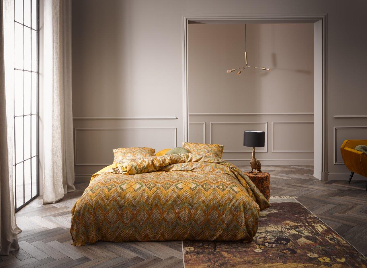 Ein Bettbezug-Set aus mehreren Kopfkissen und einer Bettdecke bezogen mit Satin Bettwaesche aus 100 Prozent Baumwolle mit Muster aus Linien in der Farbe Gelb. Modell Fabienne Mustard.