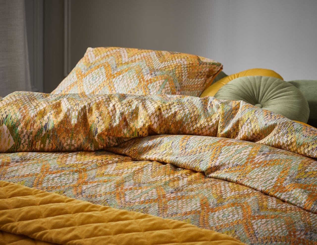 Detaildarstellung auf Kopfkissen und Bettdecke der Essenza Satin Bettwaesche Modell Fabienne Mustard.