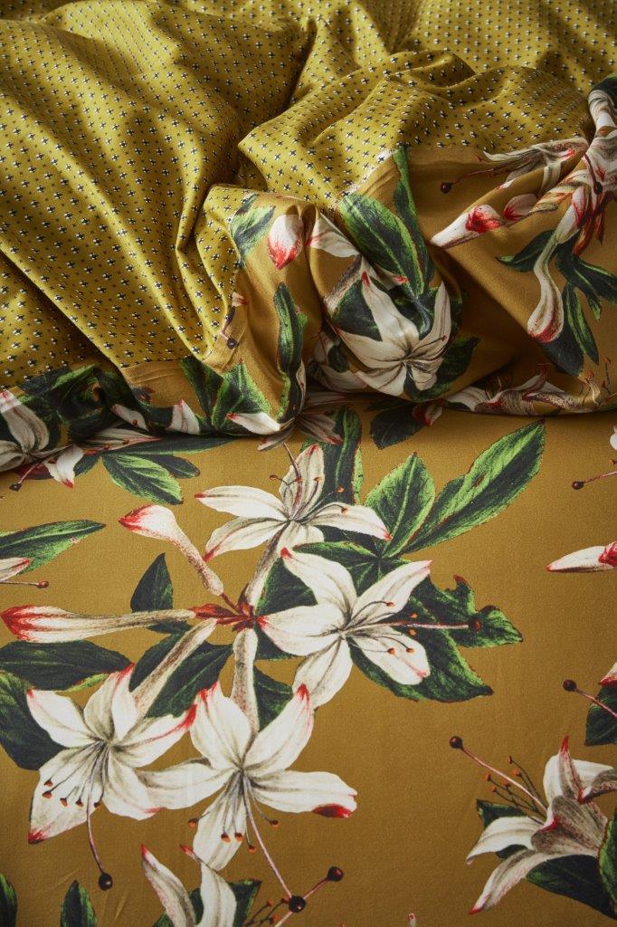 Detaildarstellung auf Kopfkissen und Bettdecke der Blueten der Essenza Satin Bettwaesche Modell Verano Ochre.