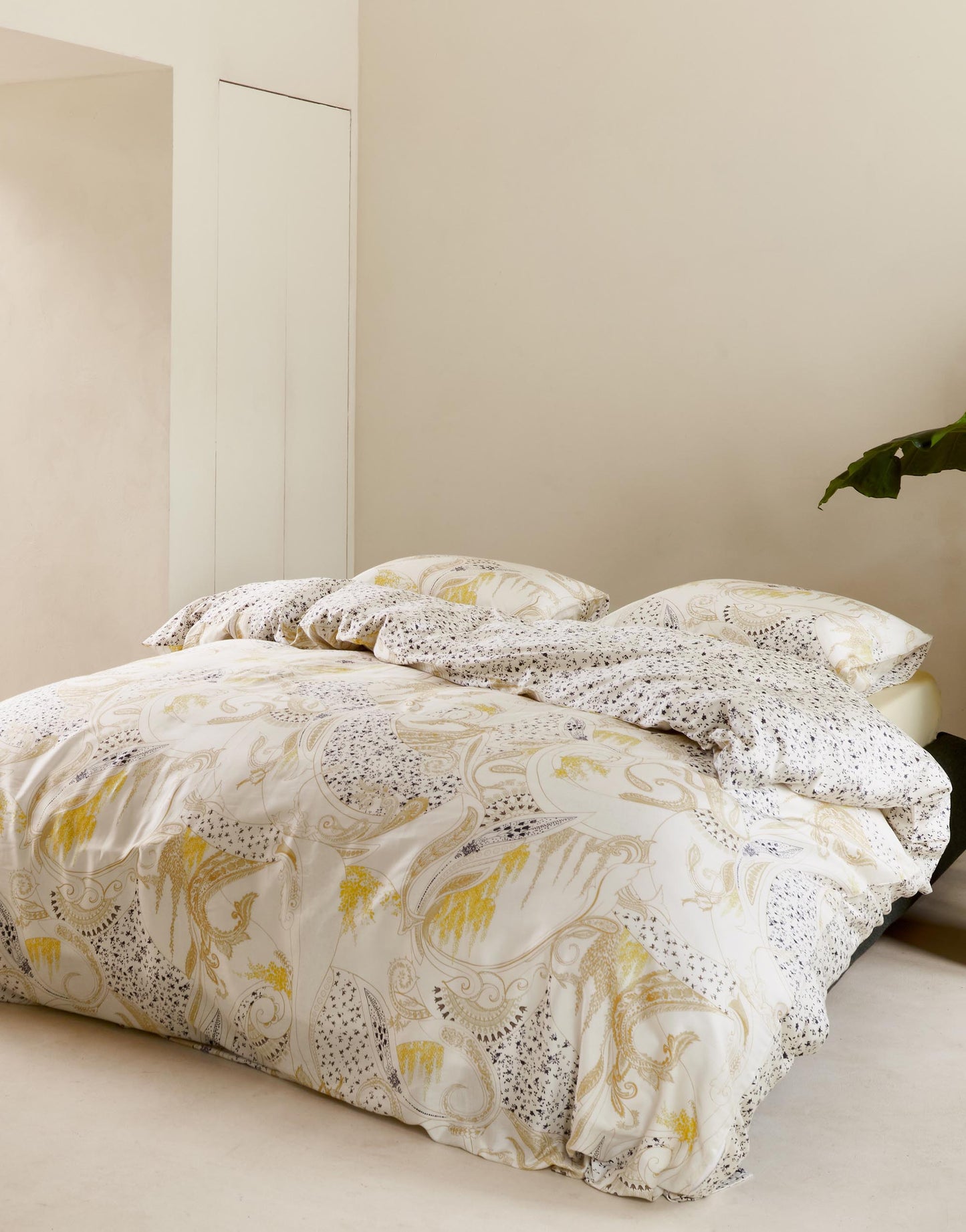 Ein Bettbezug-Set aus mehreren Kopfkissen und einer Bettdecke bezogen mit Satin Bettwaesche aus 100 Prozent Baumwolle mit Muster aus Ornamenten in der Farbe Weiss. Modell Verena Antique White.