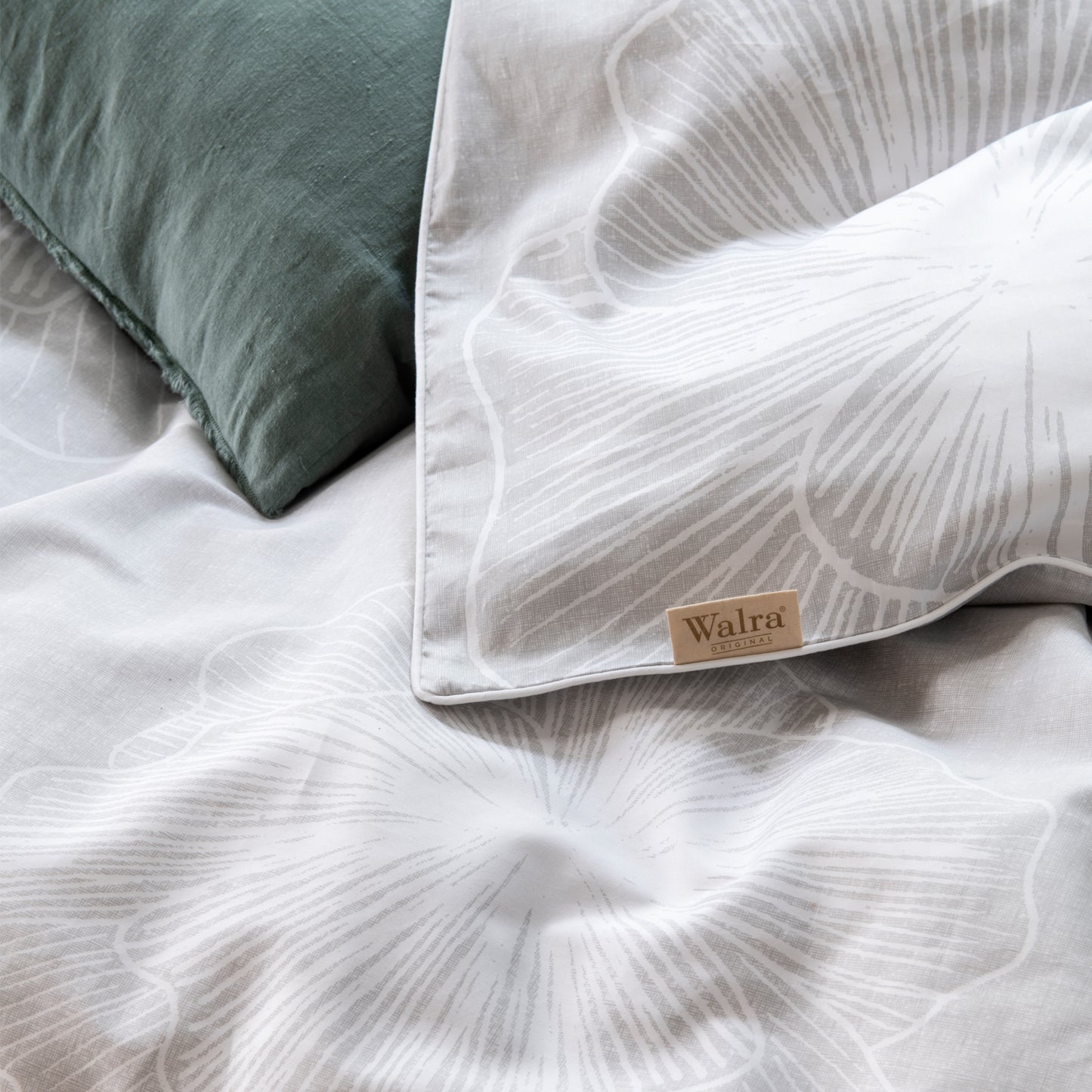 Detaildarstellung der Blueten auf Kopfkissen und Bettdecke der Satin Bettwaesche Modell Fine Feston.
