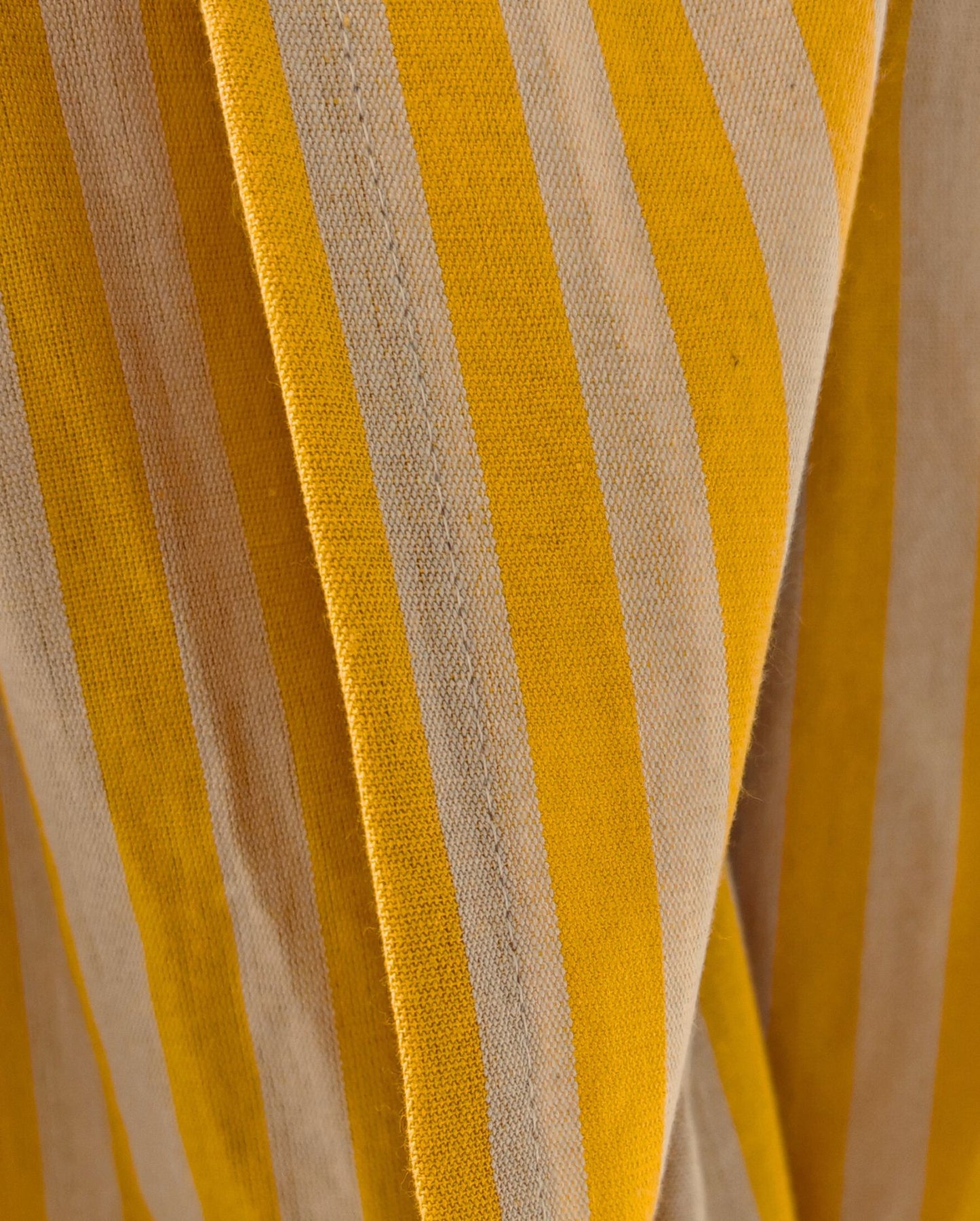Eine Detailaufnahme des Stoffes vom PIP STUDIO Strandtuch in der Farbe Gelb. Die Struktur wird hervorgehoben. Modell Hana Suma Stripe.