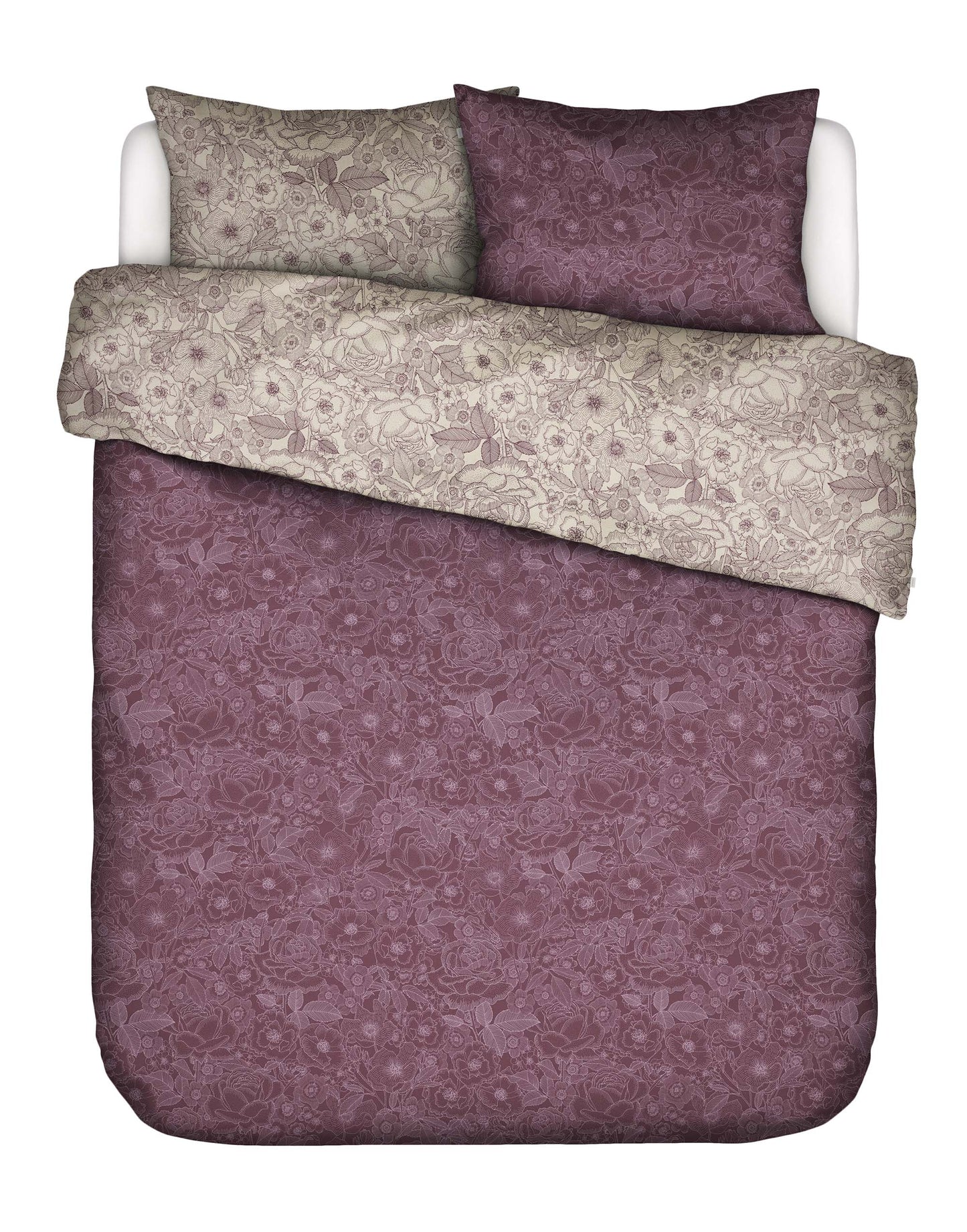 Zwei Kopfkissen und eine Bettdecke bezogen mit Twill-Baumwoll Bettwaesche von Essenza mit einem Muster aus Blumen in der Farbe Lila. Modell Camille Plum Wine.