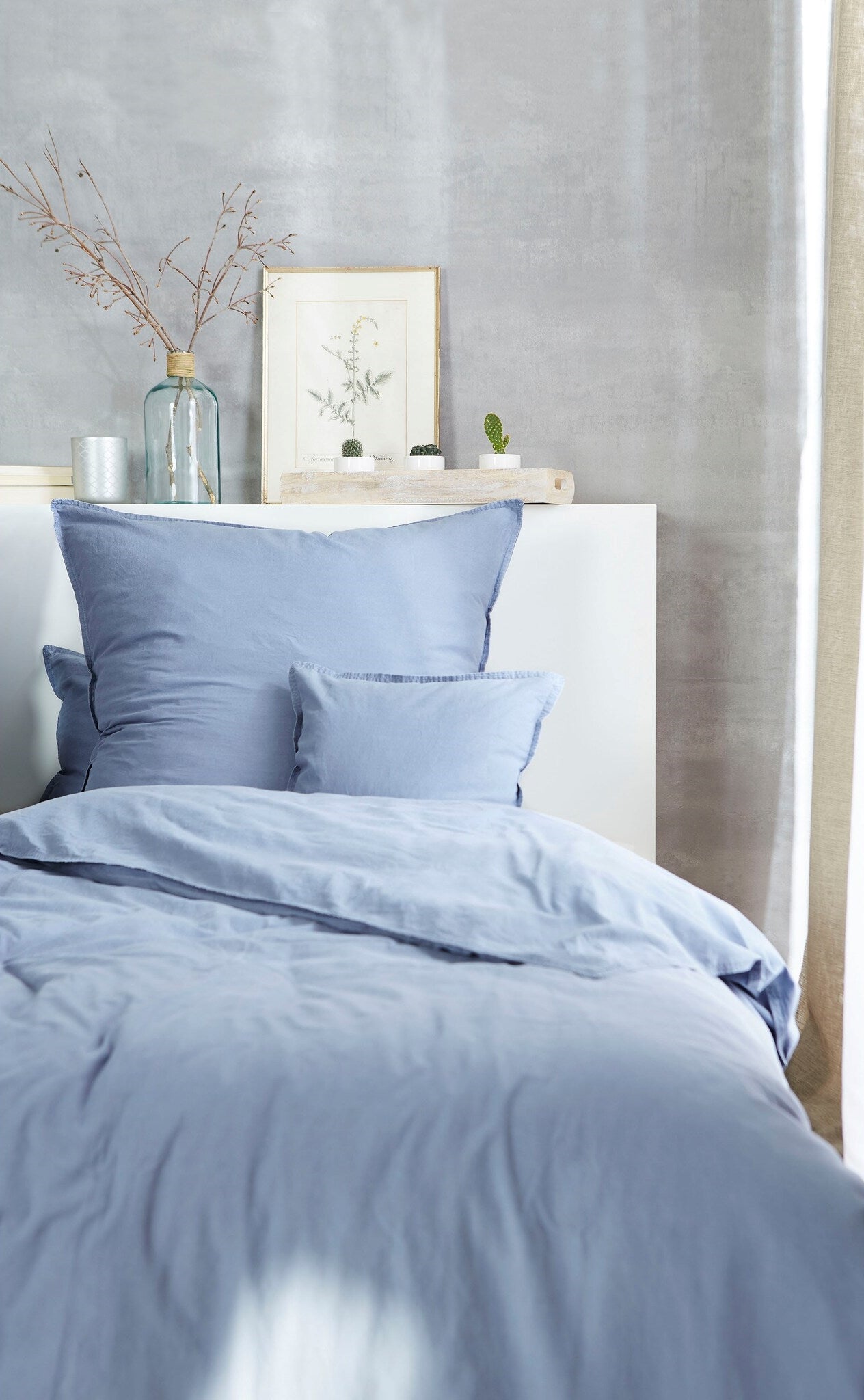 Ein Bettbezug-Set aus mehreren Kopfkissen und einer Bettdecke bezogen mit Renforce Bettwaesche aus 100 Prozent Baumwolle in der Farbe Blau. Modell Stone-Washed Blau 365.