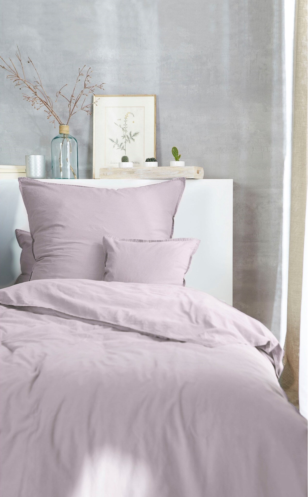 Ein Bettbezug-Set aus mehreren Kopfkissen und einer Bettdecke bezogen mit Renforce Bettwaesche aus 100 Prozent Baumwolle in der Farbe Rosa. Modell Stone-Washed Rosenholz 450.