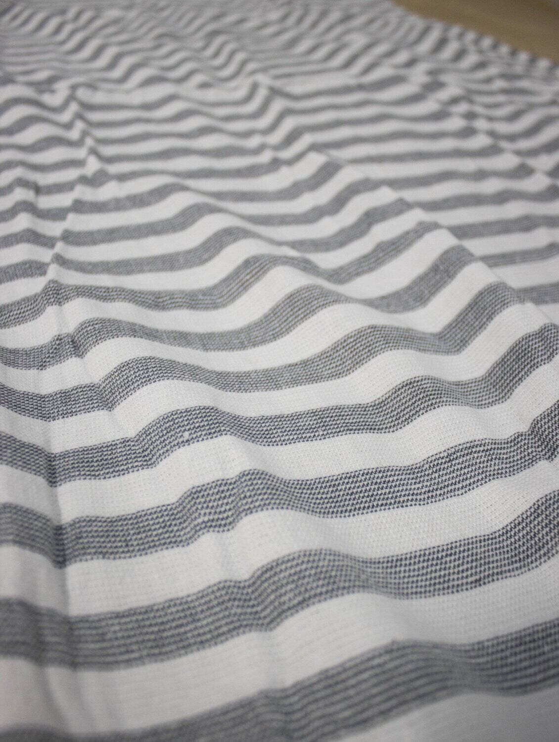 Eine Detailaufnahme des Stoffes vom Standard Line Strandtuch in der Farbe Grau. Die Struktur wird hervorgehoben. Modell Stavanger.