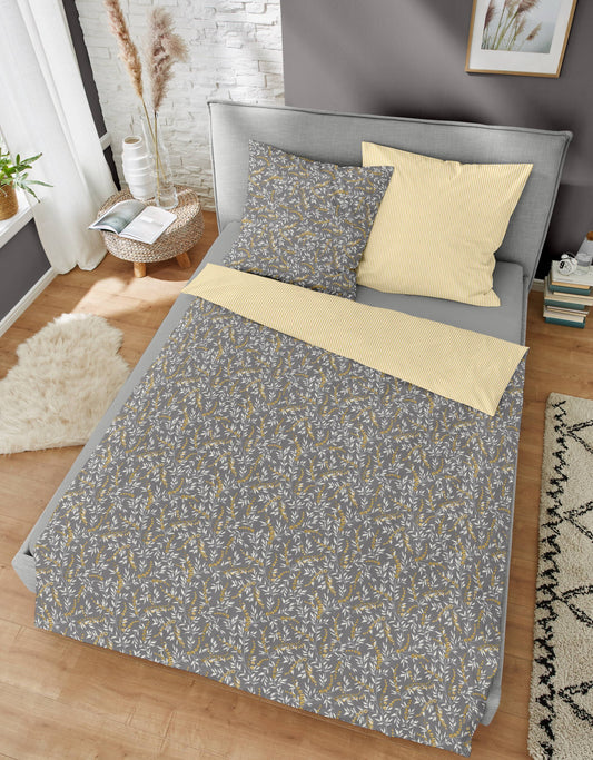 Ein Bettbezug-Set aus einem Kopfkissen und einer Bettdecke bezogen mit Edel-Biber Bettwaesche aus 100 Prozent Baumwolle mit Muster aus Zweigen in der Farbe Grau. Modell Branch.