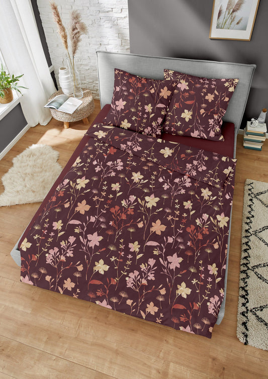 Ein Bettbezug-Set aus einem Kopfkissen und einer Bettdecke bezogen mit Edel-Biber Bettwaesche aus 100 Prozent Baumwolle mit Muster aus Blumen in der Farbe Bordeaux. Modell Charm.