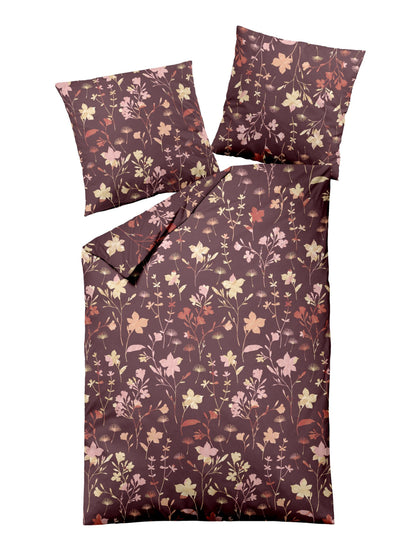 Zwei Kopfkissen und eine Bettdecke bezogen mit Edel-Biber Bettwaesche von Dormisette mit einem Muster aus Blumen in der Farbe Bordeaux. Modell Charm.