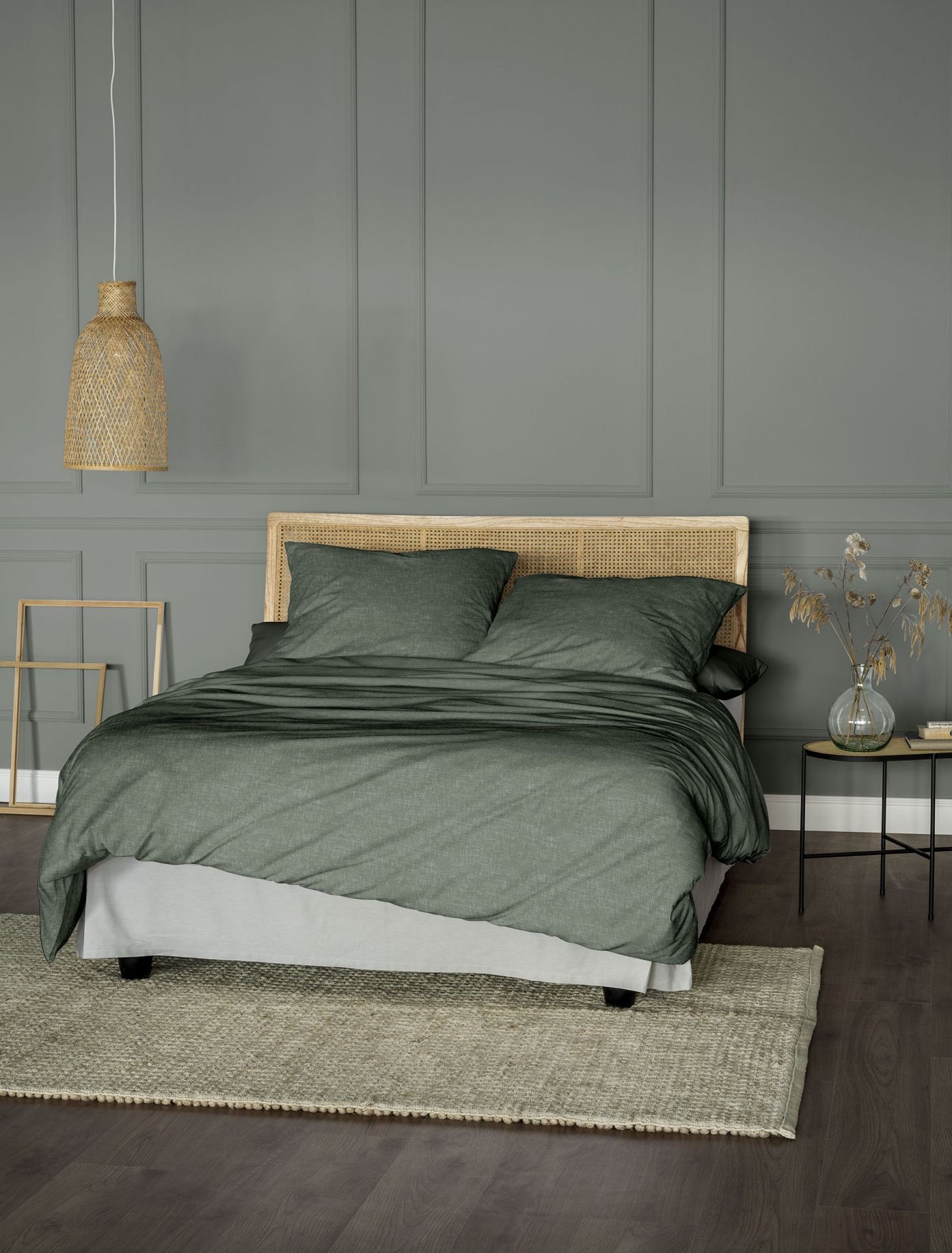 Auf einem Bett liegen mehrere Kopfkissen und eine Bettdecke bezogen mit Edel-Feinbiber Bettwaesche aus 100 Prozent Baumwolle in der Farbe Gruen. Modell Koala Gruen.
