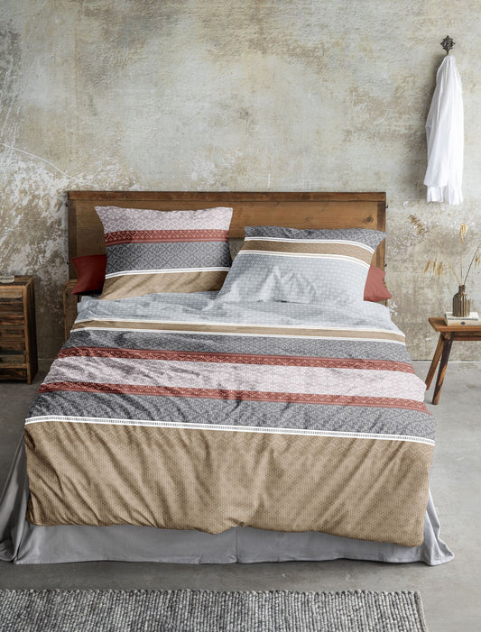 Auf einem Bett liegen mehrere Kopfkissen und eine Bettdecke bezogen mit Edel-Feinbiber Bettwaesche aus 100 Prozent Baumwolle mit Muster aus geographischen Formen in der Farbe Rot. Modell Panda Rot.