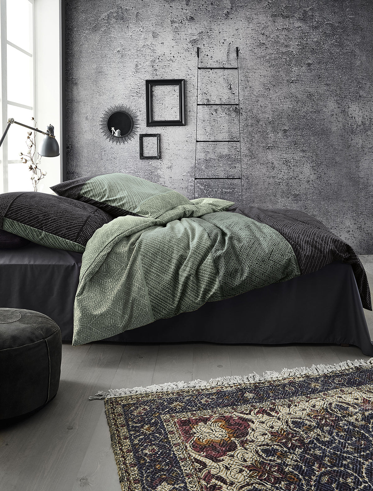 Auf einem Bett liegen mehrere Kopfkissen und eine Bettdecke bezogen mit Edel-Feinbiber Bettwaesche aus 100 Prozent Baumwolle mit Muster aus horizontalen Streifen in der Farbe Gruen. Modell Verdona.