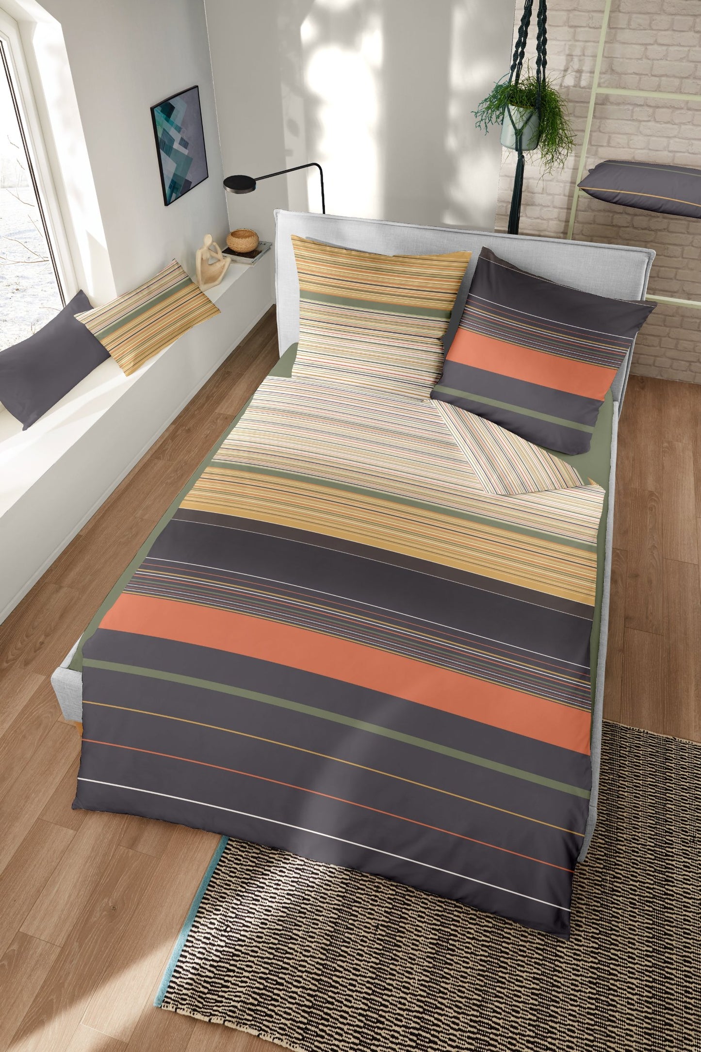Ein Bettbezug-Set aus einem Kopfkissen und einer Bettdecke bezogen mit Feinbiber Bettwaesche aus 100 Prozent Baumwolle mit horizontalen Streifen in der Farbe Braun. Modell Cityscape