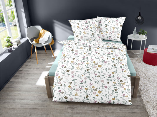 Ein Bettbezug-Set aus einem Kopfkissen und einer Bettdecke bezogen mit Feinbiber Bettwaesche aus 100 Prozent Baumwolle mit Muster aus Blumen in der Farbe Weiss. Modell Eternal Spring.