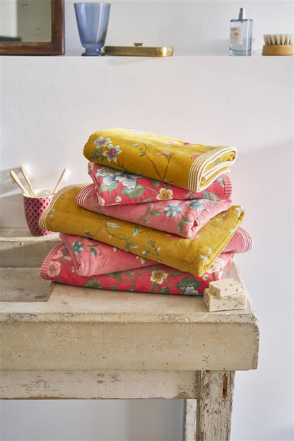 Ein Stapel aus mehreren Handtuechern in verschiedenen Groessen von PIP STUDIO die aufeinander liegen mit Muster aus Blumen in der Farbe Gelb. Modell Les Fleurs Yellow.