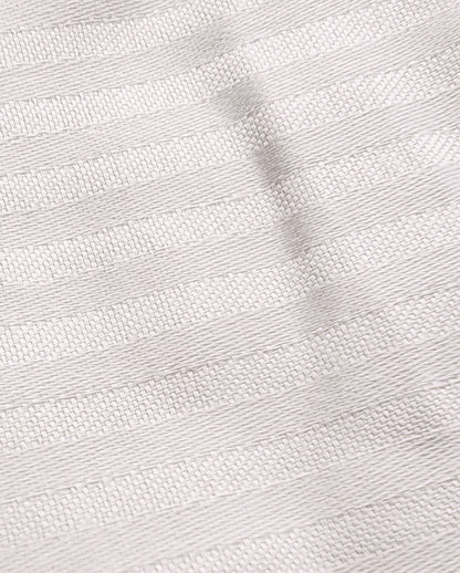 Detailaufnahme einer weißen Bettwaesche mit Streifenmuster. Die Struktur wird hervorgehoben