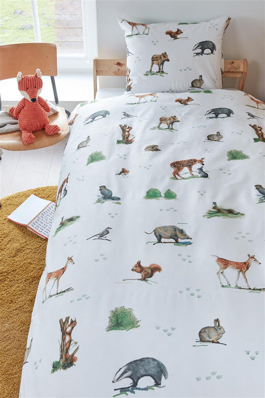 In einem Kinderschlafzimmer steht ein Kinderbett mit einem Kopfkissen und einer Bettdecke bezogen mit kuscheliger beddinghouse Bettwaesche aus 100 Prozent Baumwolle mit Illustrationen von Tieren in der Farbe Weiss. Modell Forest Animals.