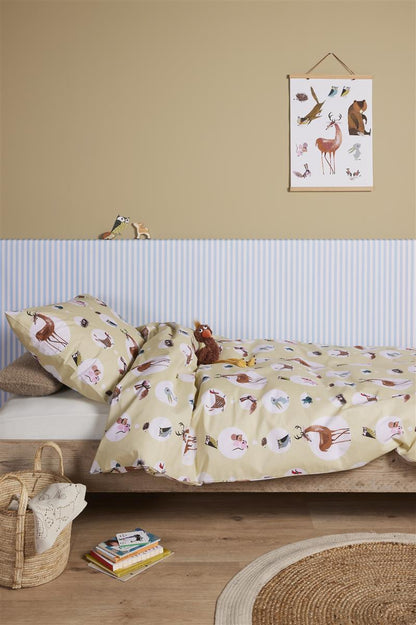 In einem Kinderschlafzimmer steht ein Bett mit einem Kopfkissen und einer Bettdecke bezogen mit kuscheliger beddinghouse Bettwaesche aus 100 Prozent Baumwolle mit Illustrationen von Tieren in der Farbe Weiss. Modell Forest Friends.