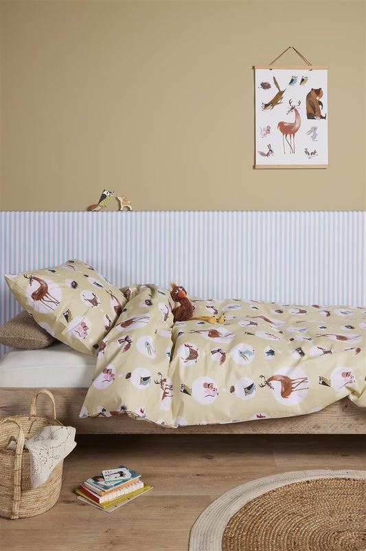 In einem Kinderschlafzimmer steht ein Bett mit einem Kopfkissen und einer Bettdecke bezogen mit kuscheliger beddinghouse Bettwaesche aus 100 Prozent Baumwolle mit Illustrationen von Tieren in der Farbe Weiss. Modell Forest Friends.