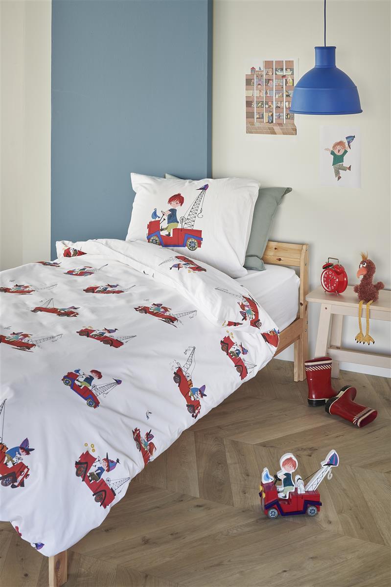 In einem Kinderzimmer steht ein Kinderbett mit einem Kopfkissen und einer Bettdecke bezogen mit kuscheliger beddinghouse Bettwaesche aus 100 Prozent Baumwolle mit Illustrationen von Kranwagen in der Farbe Weiss. Modell Kranwagen Rot.