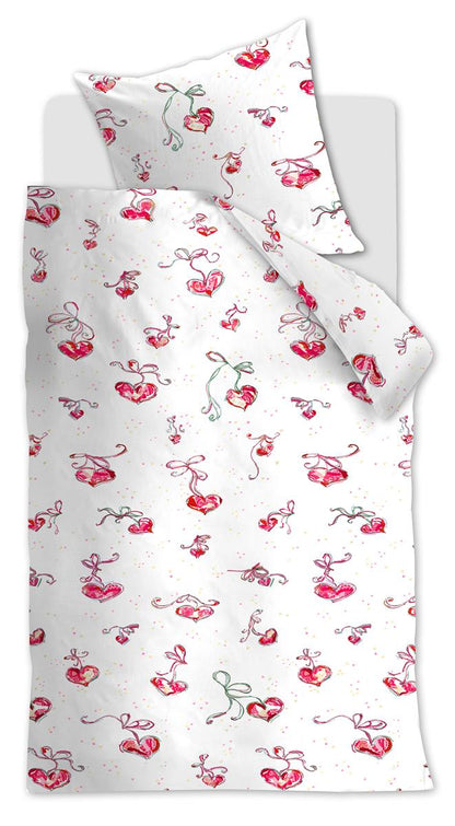 Ein Bett mit einem Kopfkissen und einer Bettdecke bezogen mit kuscheliger beddinghouse Bettwaesche aus 100 Prozent Baumwolle mit Illustrationen von Herzen und Schleifen in der Farbe Weiss. Modell Love.
