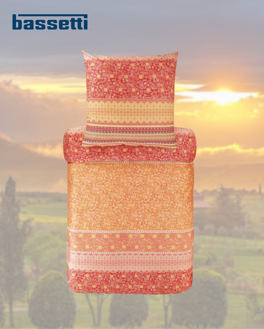 Ein Kopfkissen und eine Bettdecke bezogen mit eleganter Mako-Satin Bettwaesche von bassetti mit einem Paisleymuster in der Farbe Orange. Modell Atrani RB