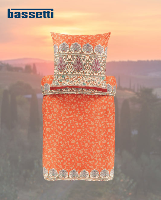 Ein Kopfkissen und eine Bettdecke bezogen mit eleganter Mako-Satin Bettwaesche von bassetti mit einem Paisleymuster in der Farbe Orange. Modell Barisano 01