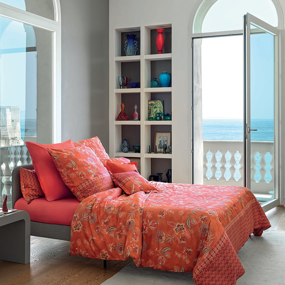Mehrere Kopfkissen und eine Bettdecke bezogen mit eleganter Mako-Satin Bettwaesche von bassetti mit einem Paisleymuster in der Farbe Orange. Modell Chiaia R1.