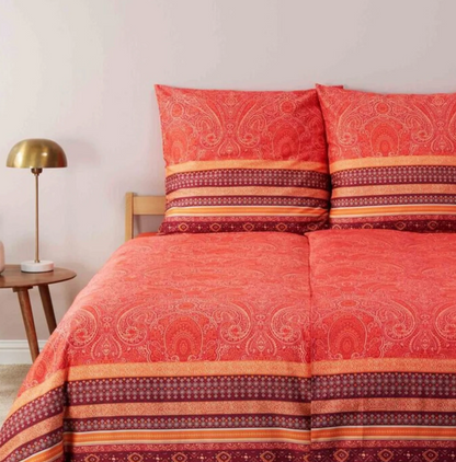 Mehrere Kopfkissen und eine Bettdecke bezogen mit eleganter Mako-Satin Bettwaesche von bassetti mit einem Paisleymuster in der Farbe Rot. Modell Maser R1