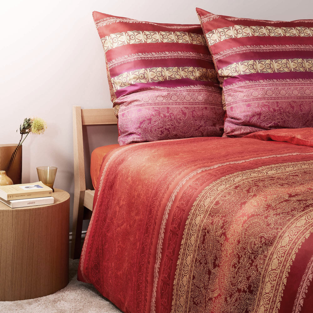 Zwei Kopfkissen und eine Bettdecke bezogen mit eleganter Mako-Satin Bettwaesche von bassetti mit einem Paisleymuster in der Farbe Bordeaux. Modell Monreale R1