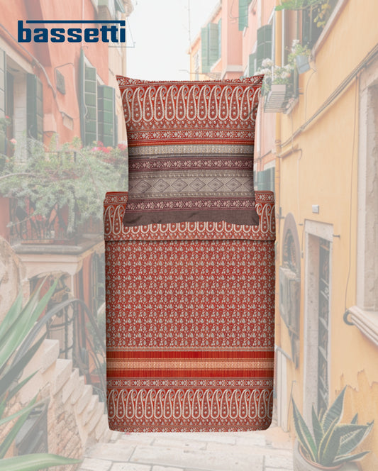 Ein Kopfkissen und eine Bettdecke bezogen mit eleganter Mako-Satin Bettwaesche von bassetti mit einem Paisleymuster in der Farbe Rot. Modell Piazza Ducale R2.