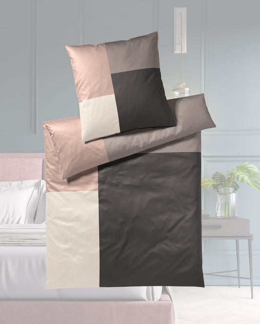 Ein Bettbezug-Set aus einem Kopfkissen und einer Bettdecke bezogen mit seidig-weicher Mako-Satin Bettwaesche aus 100 Prozent Baumwolle mit Karomuster in der Farbe Braun. Modell Karo Braun.