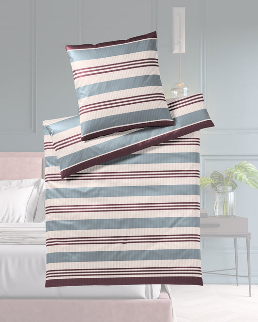 Ein Bettbezug-Set aus einem Kopfkissen und einer Bettdecke bezogen mit seidig-weicher Mako-Satin Bettwaesche aus 100 Prozent Baumwolle mit horizontalen Streifen in der Farbe Blau. Modell Stripe Blue.